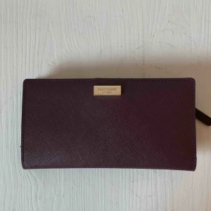  - Äkta Kate Spade plånbok.  Flera kort hållare samt dragkedja på ett fack.  Använd 2-3 gånger, som ny med inga repor eller fläckar.   Finns i centrala Stockholm eller köpare betalar frakt. 
