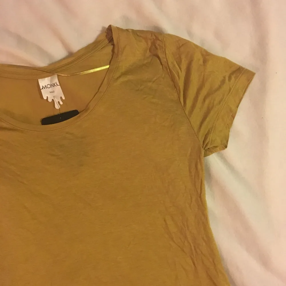 Oanvänd senapsgul T-shirt från monki. T-shirts.