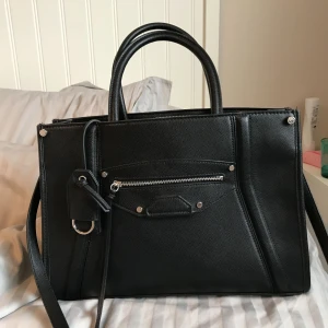  - Helt oanvänd väska från H&M. Nyskick och nypris 349kr. Måttet är ca 40cm x 13 x 25. Går att få exakt mått vid intresse samt fler bilder.  Kan mötas i Stockholm eller skickas mot halva fraktkostnaden. 