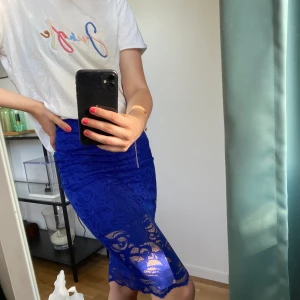 T-shirt och kjol - Vanlig vit t-shirt med ett snyggt tryck från Mango. Blå kjol från en tidigare guldkollektion H&M hade. Pris kan diskuteras. 