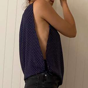Top from pull&bear open on the sides. Color is blue with tiny pink rectangles. 