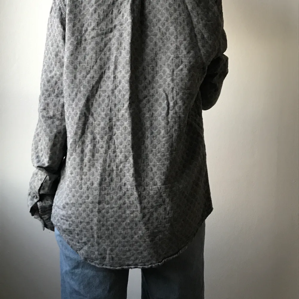 Grå skjorta från Samsøe & Samsøe. Ganska tjockt och mjukt material. Storlek står inte men sitter fint lite oversized på mig som är S/36. 100% bomull. . Skjortor.