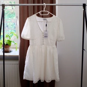 Klänning - Vit klänning som ärver oanvänd. Lappen sitter kvar. 
