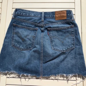 Levi’s jeanskjol - Jeanskjol från Levi’s i storlek 26 (S). Har en liten vit fläck på ena sidan, men syns knappt! Frakt utöver. 