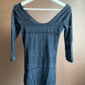 Svart tights klänning  - Svart klännings som har en bred uringning. Med fina detaljer i tyget. Frakt tillkommer. Väldigt stretchig