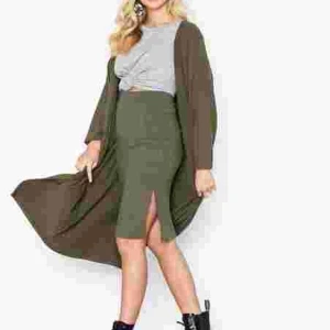 Svart cardigan med fickor  - En lång svart cardigan med två fickor i fram! Ribbad och skönt material. Endast använd ett fåtal gånger och så gott som ny! Dena långa ”kofta ” har långa armar som är luftiga och den storyer absolut inte åt någon stans. Är från Nellys egna märke NLY TREND