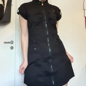 Bench. Svart klänning - Frakt INGÅR i priset! En väldigt annorlunda klänning m. tuffa detaljer 🥀🖤 den har en dragkedja som går ända längst ner. Har även små nitar, hölje för bälte och en liten ficka vid bysten! Detta är storlek M men passar väldigt bra på en S ❤