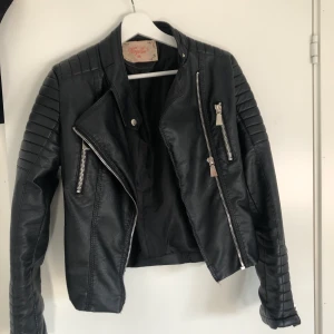 Svart skinnjacka från chiquelle, strl 38 - Använd ett fåtal gånger, alltså i väldigt bra skick. Passar dig som har XS-S, den är i strl 38. Köpt från chiquelle ”Moto jacket Black”, ordinarie pris 699kr. Frakten står man själv för.