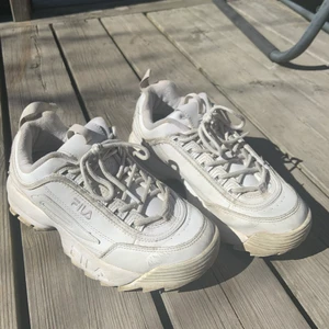Fila disruptor - vita FILA disruptor i storlek 38 1/2, välanvända för ett tag sedan men nu inte på ett tag! Detalj: tygbiten längst bak har gått sönder men syns inte om man lägger den som den ska då det är naturligt, men lätt att sy för att fixa. 