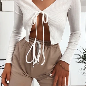 Vit ribbad topp me snörning  - Helt oanvänd ribbad topp med snörning, väldigt populär och snygg! Går att få detaljbilder i chatt, frakt tillkommer på 50kr. 