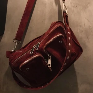 Nunoo Bag - As snygg vinröd nunoo väska i sammet! Super fin och passar till typ allt. Väskan är sååå rymlig och man får plats med såå mycket! Det är mellan modellen!