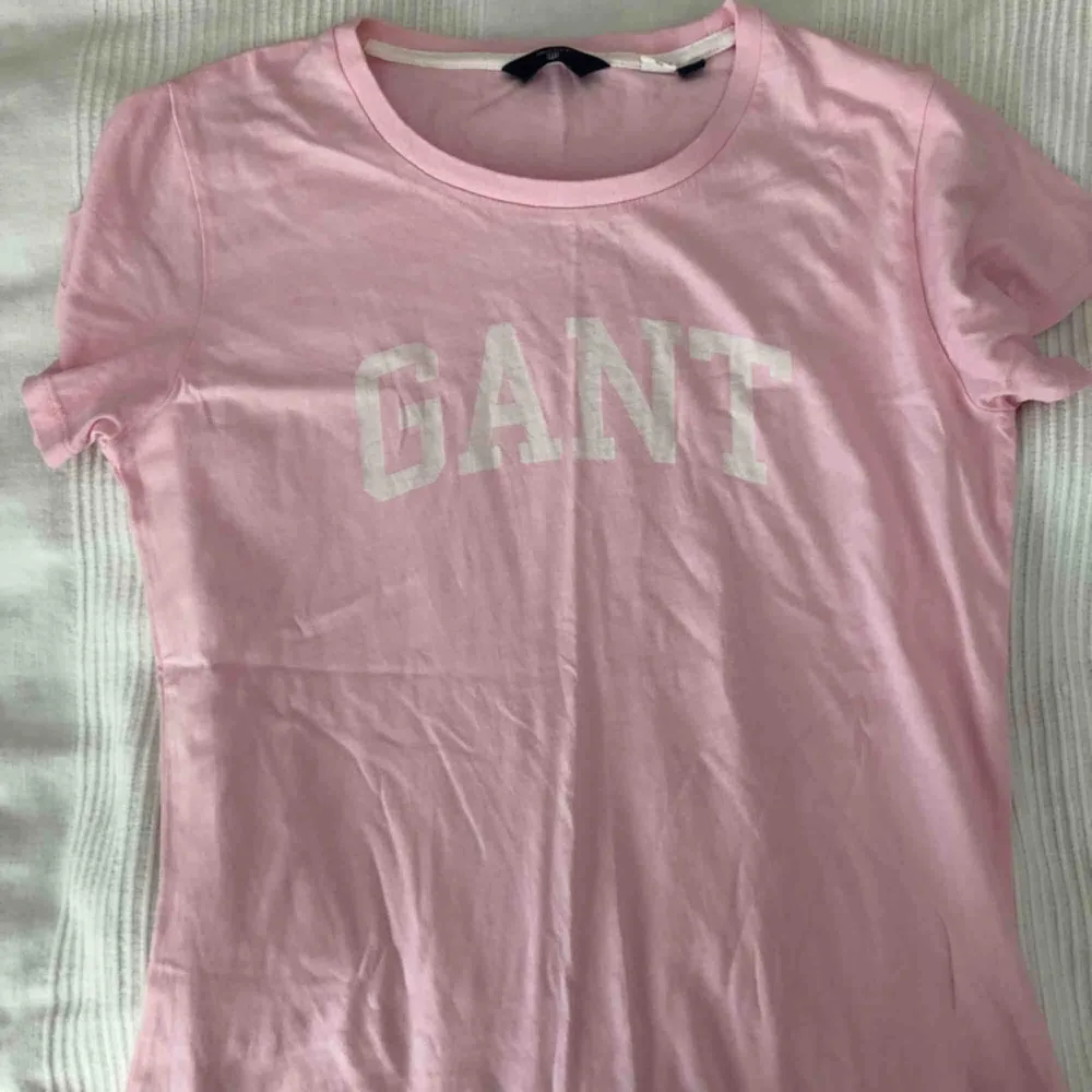 rosa gant t-shirt med vitt tryck i bra skick och använd fåtal gånger, säljer nu då det inte är min stil längre.. T-shirts.