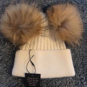 Mössa med pälsbollar (äkta)  - Superfin mössa i angora med två avtagbara pälsbollar. Äkta päls. Säljer pga köpte två olika färger & den här vita har inte kommit till användning. 
