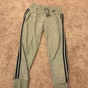  - Snygga Adidasbyxor som ej kommer till användning! Riktigt snygga. De vanliga traditionella tre blå strecken på sidan av benet. Använda 3 ggr. Köpta på Stadium för 449:- Frakt ca 54kr spårbar frakt 63kr. De är gråa & strecken marinblå. Möts upp i Göteborg