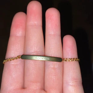 Armband från Bud to Rose! - Skitfint guldigt (ej äkta guld) armband från Bud to Rose. Justerbart! Det står ”Rock on” på framsidan! Bra skicka, endast några små små skråmor!! 30 kr + frakt! 
