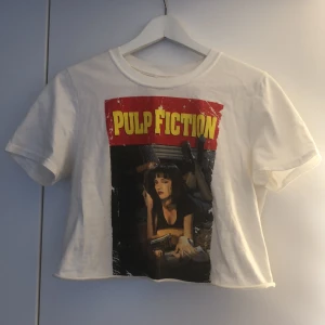 Pulp fiction topp - En crop top med Pulp fiction tryck. Sparsamt använd. Hittar ingen storlek på den men den är som xs-s. Köparen står för frakt