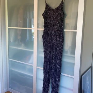 Jumpsuit - Marinblå och mönstrad jumpsuit ifrån H&M. Endast använd ett par gånger och är därmed i ett bra skick. 40 kr + frakt