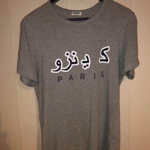 Kenzo arabic print t-shirt stl M - Grå t-shirt från Kenzo i modell Arabic print. Storleken är M. Begagnad men i fint skick. Nypris 1200kr