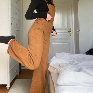 Orange/bruna hängselbyxor  - Ett par jättefina orange/bruna hängselbyxor från Pull&Bear! Jag har använt dem några få gånger men tyvärr kommer dem inte till användning längre och därför säljer jag dem😊 frakt tillkommer 