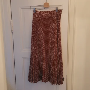 Kjol - Veckad kjol från weekday. Superfin men har tyvärr inte kommit till användning mer än en gång för min del. Mönster i brunt och vitt. Dragkedja och knäppning på ena sidan