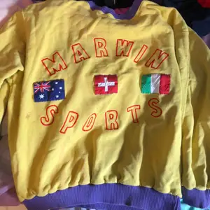 Snygg vintage oversized sweatshirt som är gul och ljuslila me tre flaggor på, väldigt bra skick aldrig använd av mig men köpt på second hand!