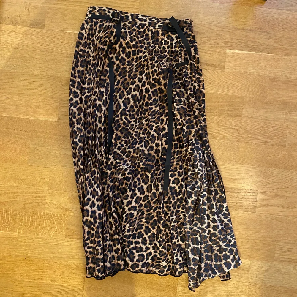 Säljer min snygga leopard mönstrade kjol som är plisserad. Den har även en slits längst ner som blir en jättefin detalj! Använd 1 gång! Man knyter den upptill med ett snöre vilket jag tycker blir så snyggt!!. Kjolar.