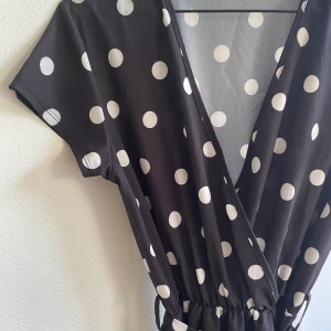 Prickig långklänning - Svart/prickig långklänning i ”baddräktsliknande” material. Utmärkt till cykelturen eller picknicken i sommar 🌊  Går  ner till tårna på mig som är 169cm. Nyskick. Hämtas i Sundbyberg, annars står köparen för frakt!