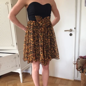  - Cool axelbandslös klänning i påfågelmönster. Mycket fint skick, använd fåtal gånger. 