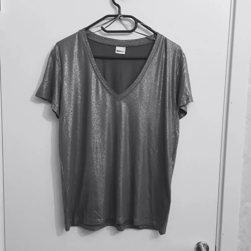 Oanvänd Glittrig T-shirt från Gina Tricot.  Frakt : 35kr. T-shirts.