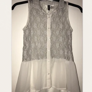  - En vit och grå blus med spets. Frakten ingår inte men hör gärna av dig om frågor 🙂