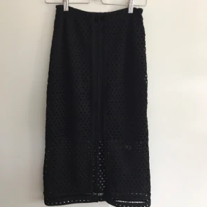  - Kjol från hm i "virkat" material, man ser igenom tyget nedtill plus en slits framtill ca 10 cm. Går strax under knäna på mig som är 165 cm.