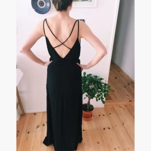  - Black evening dress with a V-cut in the front and back. Falls beautifully over your body. It has a side slit! 100%polyamide. From the Berlin based brand Ivy & Oak. NEW with Etiquette.