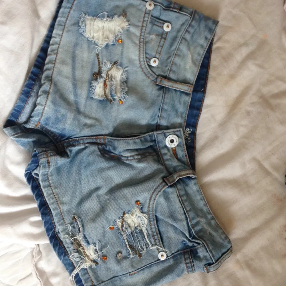 Jeansshorts ifrån Spanien! Både bak o fram hänger det små kjedjor, och diamanter. Perfekt för en rockig lock, eller en bohemisk lock!. Shorts.