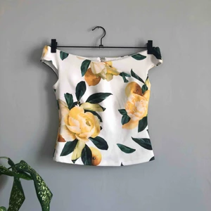  - Vacker off-shoulder blus med citron/blom-mönster. Bra kvalitet. Dragkedja baktill och något stretchigt material   Frakt på 50kr tillkommer