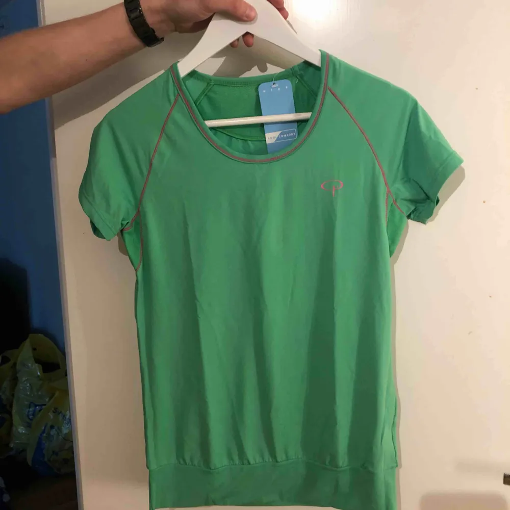 Grön träningströja som är ny med prislapp kvar. T-shirts.