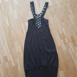  -  Svart klänning med unik dekor i metall Möts upp vid Medborgarplatsen eller Gullmarsplan alternativt skickar, köparen står för frakt