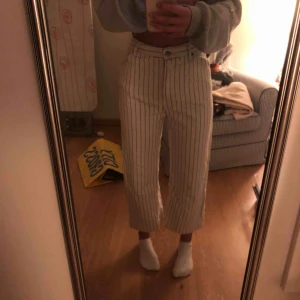  - Ett par svartvit randiga visa byxor som w lite kortare i modellen. Det har en fläck på knät 