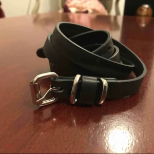  - Fur leather belt. Tunn svart. Silvriga detaljer. 