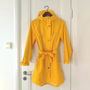  - Jättenajs gul regnjacka. Går lite över knäna (165 cm). Använd ca 5 grr, säljes pga har 17800 regnjackor.  Tyvärr liten typ "tryckfläck" på ärmen, även minifläckar under bältet och ryggen, dock inget som syns elr som man tänker på. Men därav priset! 😊🌼