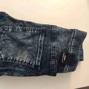  - Blåa spräckliga, stretchiga dr. Denim jeggings med dragkedja nertill. 