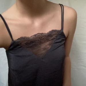 Linne med spets - Linne i silkesaktigt material och spets vid urignigen. Färgen syns lite dåligt men den är gråblå