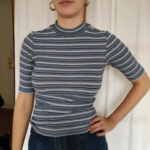 Blårandig polo med kvartslånga ärmar - Jättemjuk blå- och vitrandig tröja från Monki. Sparsamt använt. Möts upp på Södermalm annars står köparen för frakt💌💌