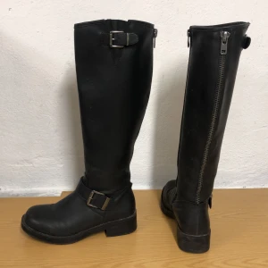 Svarta stövlar - Primeboots liknande stövlar. Strl 36 men något stora i storleken. Läderimitation, silverkedja och spännen. Köparen står för frakt 