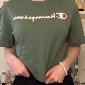 Mossgrön champion t-shirt i en kortare modell. Knappt använd, är i nyskick.