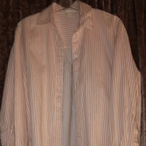 Skjorta - En randig skjorta med rosa och vita ränder.