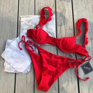Klarröd bikini - Aldrig använd, prislappar och skyddplast på underdelen sitter kvar, justerbara band på både överdelen & underdelen