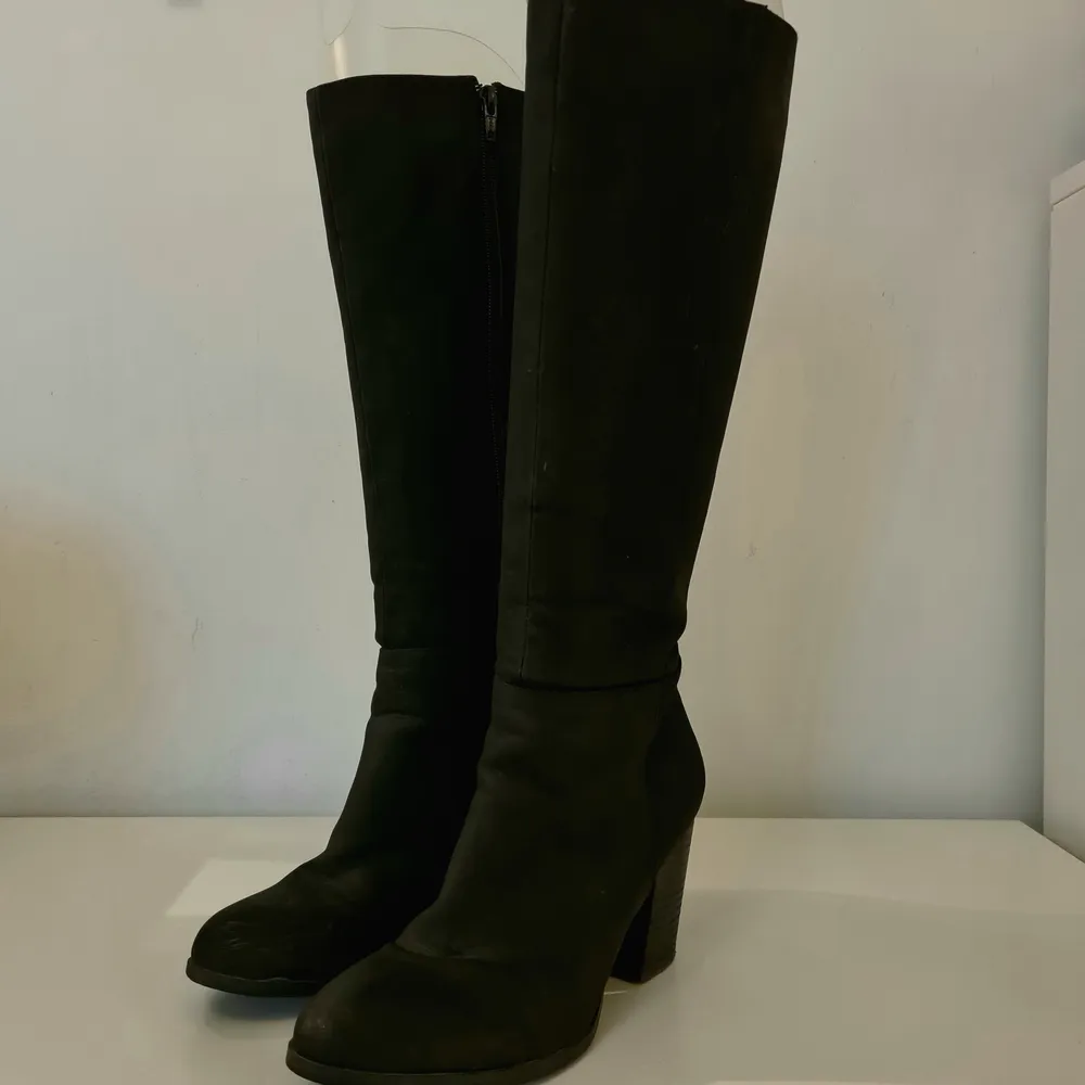 CUTEST knee high black boots in matte faux leather.  Full zipper on the inside of the shoe for easy use. They are slightly padded so they feel soft inside. 8 cm wooden block heel.  The left shoe unfortunately have a few small scratches on the back, but nothing noticeable. . Skor.