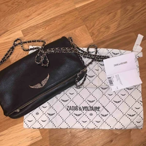  - Svart zadig & Voltaire väska i bra skick, ena grejen på dragkedjan har gått av men facket går fortfarande att öppna och stänga. Färgen på märket har skavts av lite. Inköpt i somras 2019. Nypris 3400kr