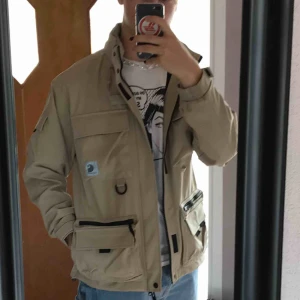  - Carhartt jacka med fickor och infvikbar luva. Använd fåtal gånger och är i bra skick. Tror den även kan vara vattentät men är inte 100% på det.