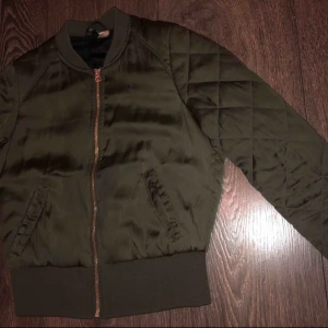  - En maringrön bomberjacka från H&M tajt passform, köpt för två år sedan och använd bara ett par gånger men är i ett väldigt bra skick.